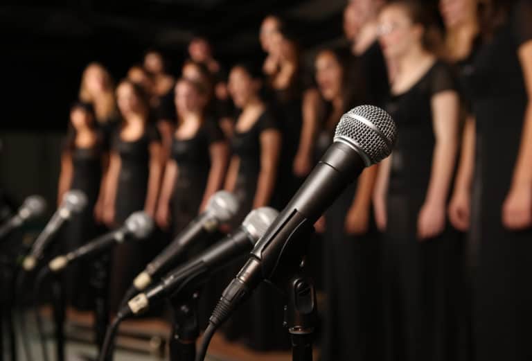 Shot of microphones with choir in the background - Maestro Musicians ...